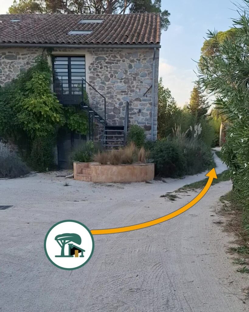 Devant la maison en pierre : ne vous arrêtez pas, continuez par la petite allée à droite.